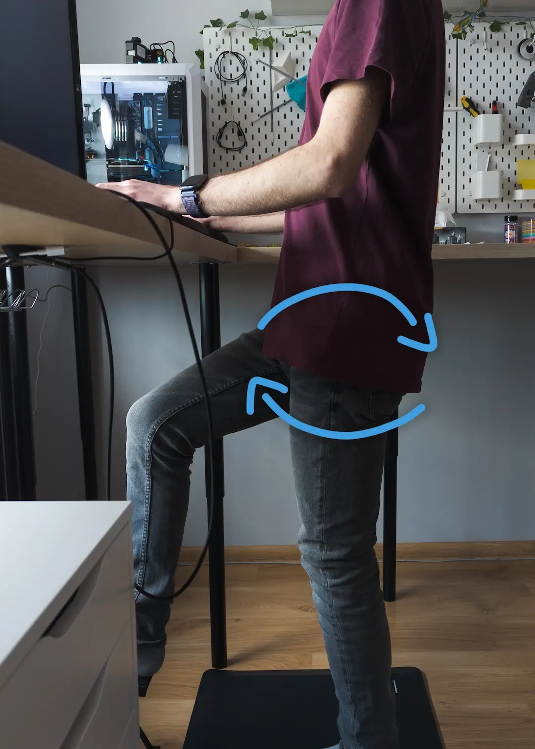 Zdjęcie sylwetki podczas pracy na stojąco z nałożoną grafiką okrężnych strzałek pokazujących prawidłowe ustawienie i rotację miednicy