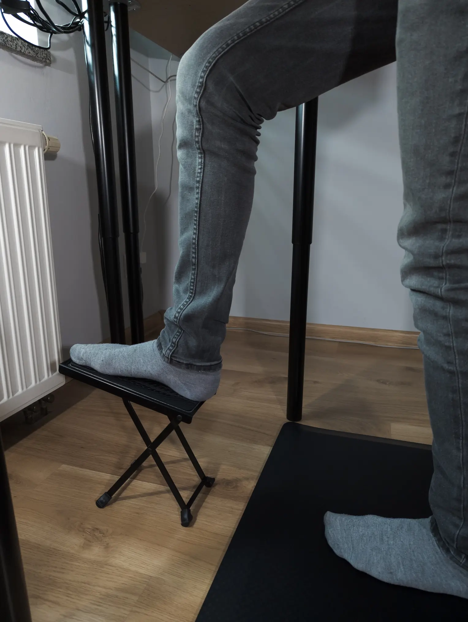 Praktyczne zastosowanie podnóżka gitarowego jako wsparcia dla nogi w celu odciążenia kręgosłupa podczas długotrwałej pracy stojącej